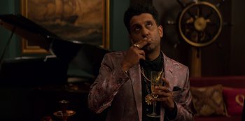 Movie still from “Murder Mystery” (2019), directed by Kyle Newacheck – A man wearing a suit and holding a glass of wine; Close Up shot, Over the shoulder angle