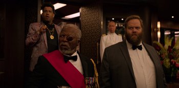 Movie still from “Murder Mystery” (2019), directed by Kyle Newacheck – A group of men standing next to each other in a room; Medium shot, Over the shoulder angle