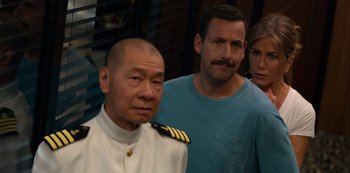 Movie still from “Murder Mystery” (2019), directed by Kyle Newacheck – A group of people standing next to each other in a room; Close Up shot, Over the shoulder angle