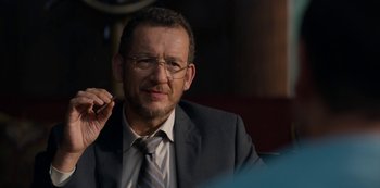 Movie still from “Murder Mystery” (2019), directed by Kyle Newacheck – A person wearing a suit and glasses; Close Up shot, Over the shoulder angle