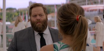 Movie still from “Murder Mystery” (2019), directed by Kyle Newacheck – A man with a long beard looking at a woman in the mirror; Close Up shot, Over the shoulder angle