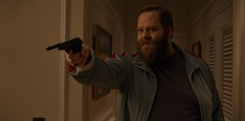 Movie still from “Murder Mystery” (2019), directed by Kyle Newacheck – A man holding a gun in a room; Medium shot, Low angle