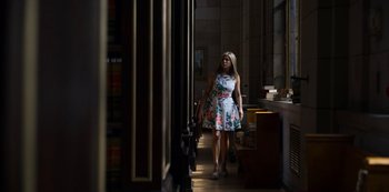 Movie still from “Murder Mystery” (2019), directed by Kyle Newacheck – A woman walking down a hallway in a library; Wide shot, Low angle