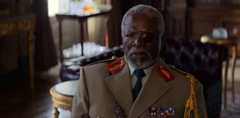 Movie still from “Murder Mystery” (2019), directed by Kyle Newacheck – An older man wearing a military uniform and wearing glasses; Close Up shot, Over the shoulder angle