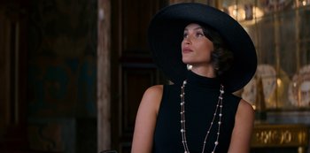 Movie still from “Murder Mystery” (2019), directed by Kyle Newacheck – A woman in a black dress and a black hat; Close Up shot, Low angle