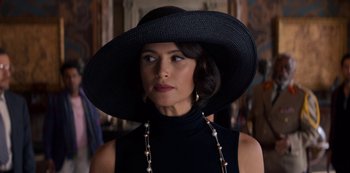 Movie still from “Murder Mystery” (2019), directed by Kyle Newacheck – A woman in a black dress and a black hat; Close Up shot, Over the shoulder angle