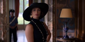 Movie still from “Murder Mystery” (2019), directed by Kyle Newacheck – A woman in a black dress and a black hat; Medium shot, Low angle