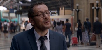 Movie still from “Murder Mystery” (2019), directed by Kyle Newacheck – A person wearing a suit and tie; Close Up shot, Over the shoulder angle