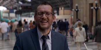 Movie still from “Murder Mystery” (2019), directed by Kyle Newacheck – A person wearing a suit and tie; Close Up shot, Over the shoulder angle