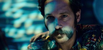 Movie still from “Mute” (2018), directed by Duncan Jones – A man with a beard and mustache holding a cigarette; Close Up shot, Low angle