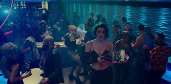 Movie still from “Mute” (2018), directed by Duncan Jones – A woman holding a tray of drinks; Wide shot, High angle