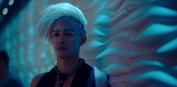 Movie still from “Mute” (2018), directed by Duncan Jones – A young man with a white wig is posing for the camera; Close Up shot, Low angle