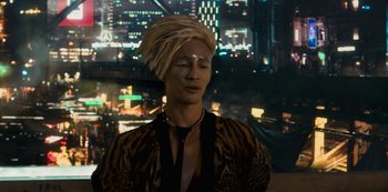 Movie still from “Mute” (2018), directed by Duncan Jones – A man with a blonde dreadlocks and a tiger print shirt; Close Up shot, Over the shoulder angle