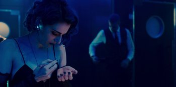 Movie still from “Mute” (2018), directed by Duncan Jones – A man and a woman in a dark room; Medium shot, Overhead angle