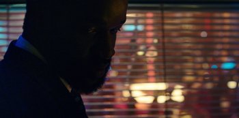 Movie still from “Mute” (2018), directed by Duncan Jones – A person wearing a suit and tie; Extreme Close Up shot, Over the shoulder angle