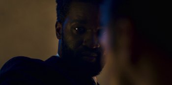 Movie still from “Mute” (2018), directed by Duncan Jones – A person with a beard looking at the camera; Close Up shot, Over the shoulder angle