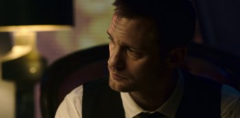 Movie still from “Mute” (2018), directed by Duncan Jones – A person wearing a shirt and tie; Close Up shot, Over the shoulder angle