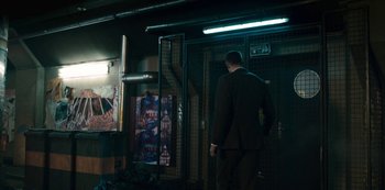 A man in a suit standing in front of a door way