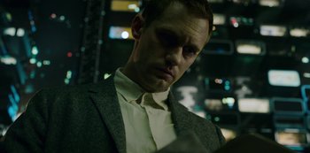 Movie still from “Mute” (2018), directed by Duncan Jones – A man wearing a suit and tie in a dark room; Close Up shot, Low angle