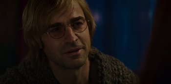 Movie still from “Mute” (2018), directed by Duncan Jones – A person wearing glasses and a sweater; Close Up shot, Over the shoulder angle