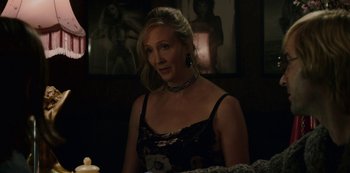 Movie still from “Mute” (2018), directed by Duncan Jones – A woman with blonde hair wearing a black dress; Close Up shot, Over the shoulder angle