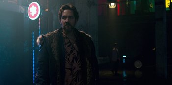 Movie still from “Mute” (2018), directed by Duncan Jones – A man with a beard wearing a fur coat; Medium shot, Low angle