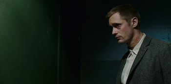 Movie still from “Mute” (2018), directed by Duncan Jones – A person wearing a suit and tie; Close Up shot, Low angle