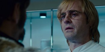 Movie still from “Mute” (2018), directed by Duncan Jones – A person wearing glasses and a white shirt; Close Up shot, Over the shoulder angle