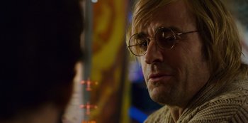Movie still from “Mute” (2018), directed by Duncan Jones – A person wearing glasses; Close Up shot, Over the shoulder angle
