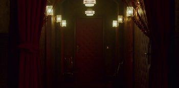 Movie still from “Mute” (2018), directed by Duncan Jones – A door way leading to a room with lights on the wall; Extreme Wide shot, Low angle
