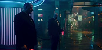 Movie still from “Mute” (2018), directed by Duncan Jones – Two men standing in a dark alley with neon lights; Wide shot, Low angle