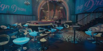 Movie still from “Mute” (2018), directed by Duncan Jones – A room with a lot of tables and chairs in it; Extreme Wide shot, High angle