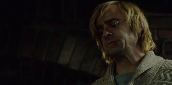 Movie still from “Mute” (2018), directed by Duncan Jones – A person wearing glasses and a sweater; Close Up shot, Low angle