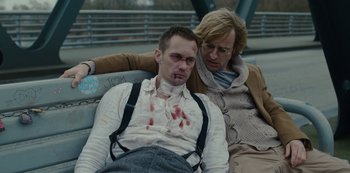 Movie still from “Mute” (2018), directed by Duncan Jones – A man and a woman are laying on a bench; Medium shot, Low angle
