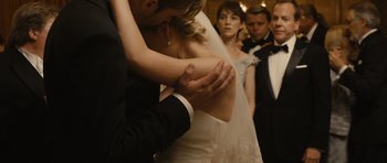 A man and a woman hugging in front of other people