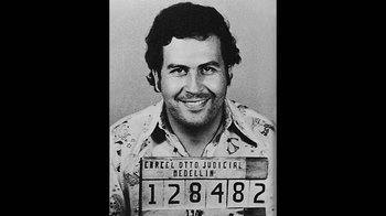 Movie still from “Narcos” (2015), created by Chris Brancato – A black - and - white photo of pablo escobar; Medium shot, Low angle