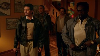 Movie still from “Narcos” (2015), created by Chris Brancato – A group of men standing in front of a staircase; Medium shot, Low angle