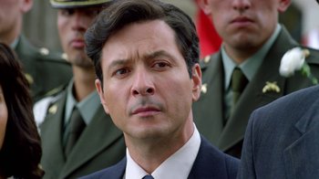 Movie still from “Narcos” (2015), created by Chris Brancato – A man in a suit and tie; Close Up shot, Over the shoulder angle