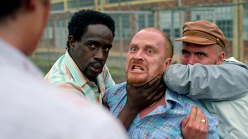 Movie still from “Narcos” (2015), created by Chris Brancato – A man with a beard is being held down by another man; Close Up shot, Over the shoulder angle