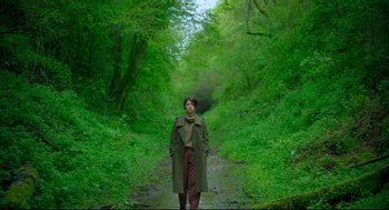 Movie still from “Men” (2022), directed by Alex Garland – A person standing in the middle of a path in the woods; Wide shot, Low angle