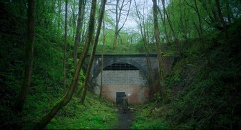 Movie still from “Men” (2022), directed by Alex Garland – An old tunnel in the middle of a forest; Extreme Wide shot, High angle