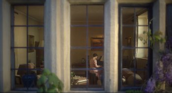 Movie still from “Men” (2022), directed by Alex Garland – A man sitting at a table playing a piano in front of a window; Wide shot, High angle