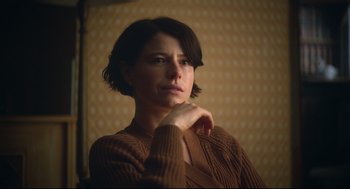 Movie still from “Men” (2022), directed by Alex Garland – A woman in a brown sweater is looking to her left; Close Up shot, Over the shoulder angle