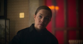 Movie still from “Men” (2022), directed by Alex Garland – A woman in a black shirt is looking at the camera; Close Up shot, Over the shoulder angle