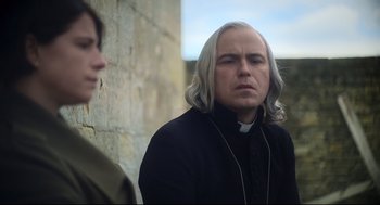Movie still from “Men” (2022), directed by Alex Garland – A man with long white hair is listening to music; Close Up shot, Over the shoulder angle