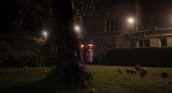 Movie still from “Men” (2022), directed by Alex Garland – Two people are standing in the grass near a tree at night; Extreme Wide shot, Over the shoulder angle