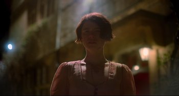 Movie still from “Men” (2022), directed by Alex Garland – A woman in a pink dress standing in the dark; Close Up shot, Low angle