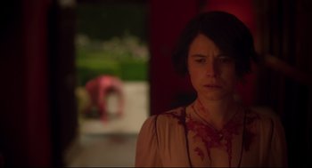 Movie still from “Men” (2022), directed by Alex Garland – A woman with blood all over her face and neck; Medium shot, Over the shoulder angle