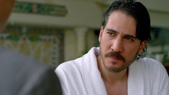 Movie still from “Narcos” (2015), created by Chris Brancato – A person wearing a robe; Close Up shot, Over the shoulder angle