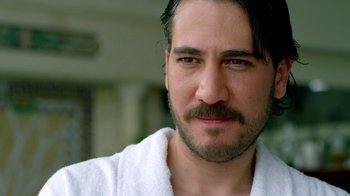 Movie still from “Narcos” (2015), created by Chris Brancato – A person wearing a robe; Close Up shot, Over the shoulder angle